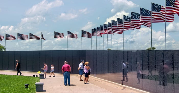 flags wave above memorial wall