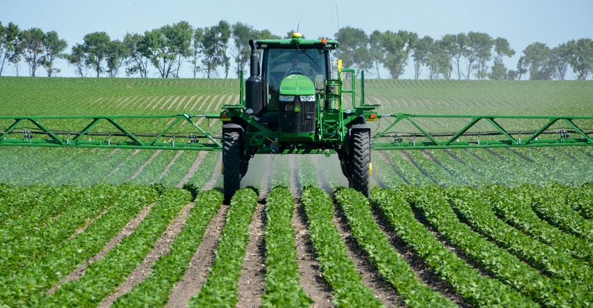 Tractor spraying herbicides on crops