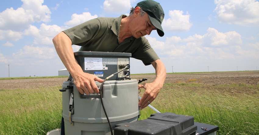 Lowell Gentry checks water gauges in field
