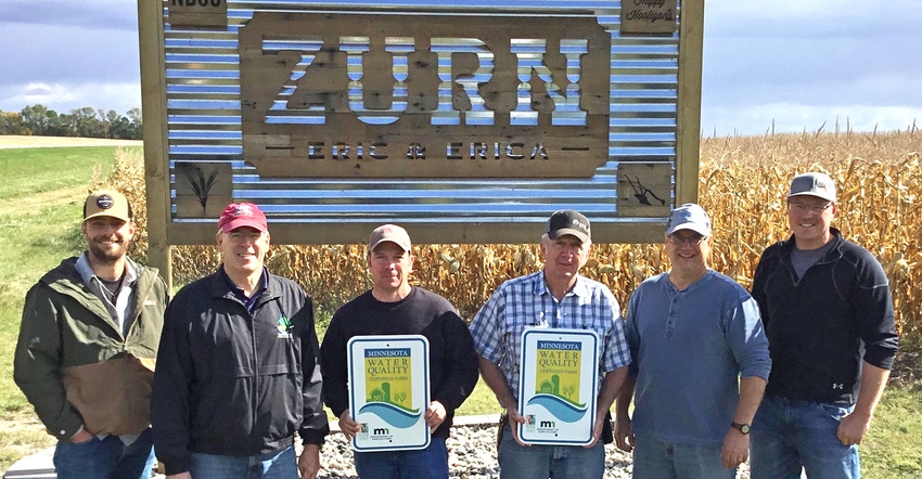 Logan Riedel, Jim Lahn, Eric and Bill Zurn, Ed Musielewicz and Dustin Jasken standing in front of Zurn farm sign