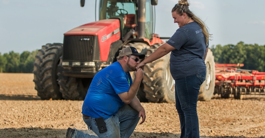 Kegan Knust proposes to Lillian Hayhurst in field with Case IH tractor in background
