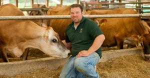 Nate Chittenden, owner of Dutch Hollow Farm in Schodack Landing, N.Y., kneels beside his cows
