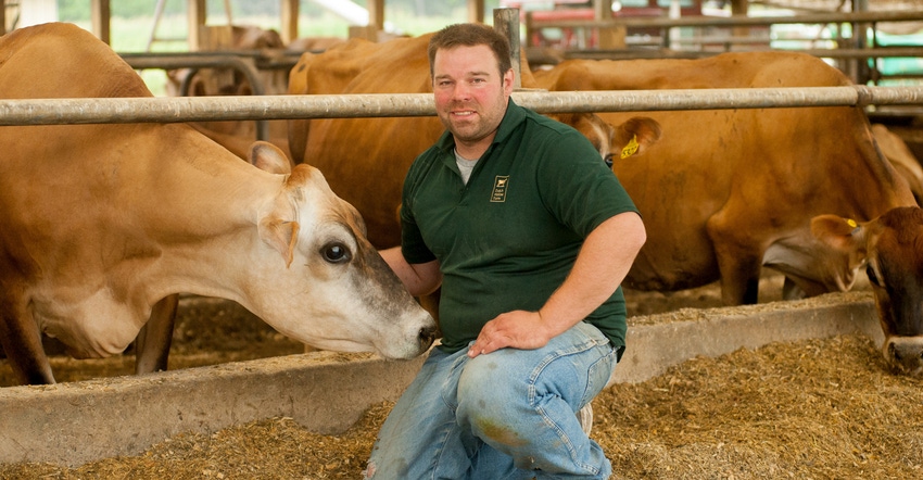 Nate Chittenden, owner of Dutch Hollow Farm in Schodack Landing, N.Y., kneels beside his cows