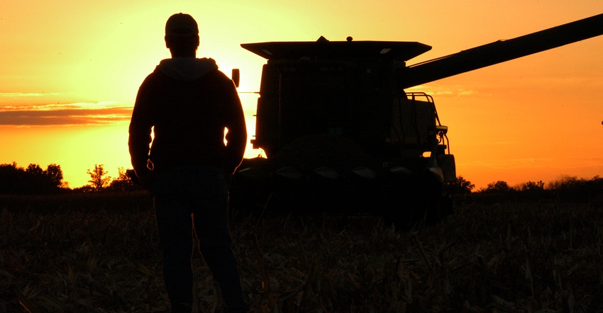 silhouette of farmer and combine