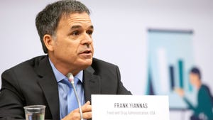 Frank Yiannas sits in a meeting with a printed name card on the table.