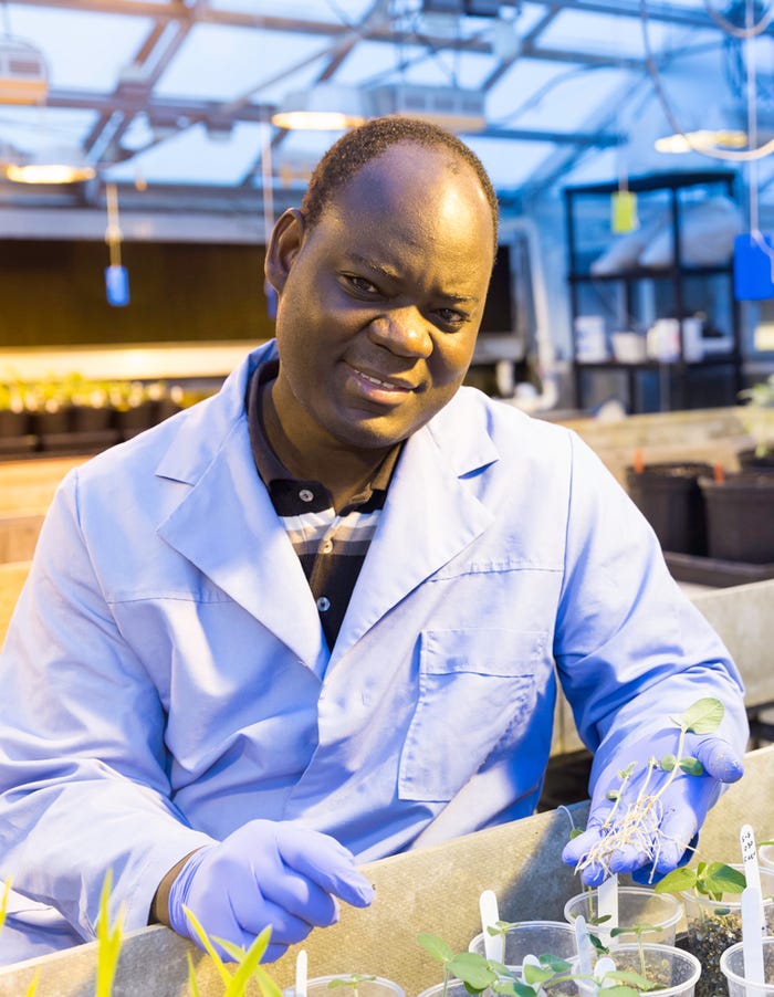 SDSU research associate Paul Okello in lab coat
