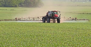 agricultural vehicle spraying chemicals on a corn field