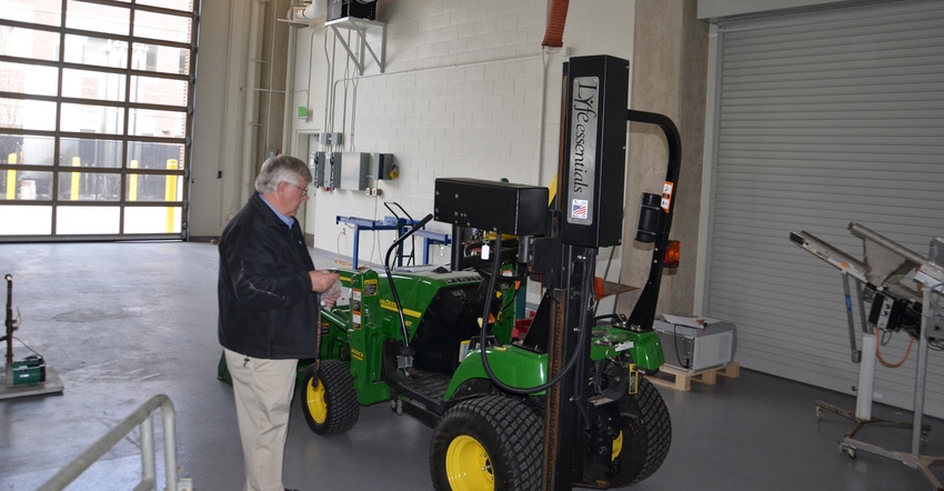 Bill Field, head of Purdue ag safety programs, prepares to demonstrate a chair lift