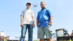Brothers Chase and Avery Hall with a drone in the sky behind them