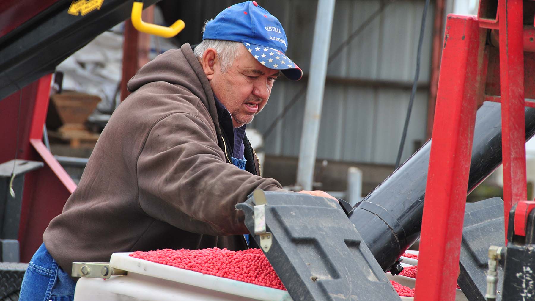 Farmer Dave Brandt loading treated seed into a planter box.