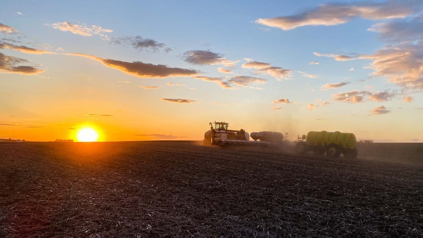 Farmer planting corn in Iowa during sunset