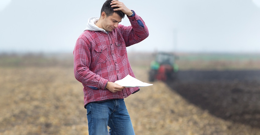 young farmer with hand on head looking worried
