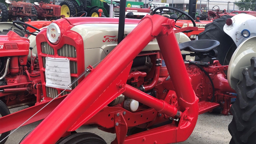  A red Ford tractor with one-armed loader on display