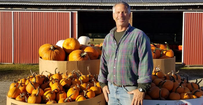 John Hand standing in front of pumpkins