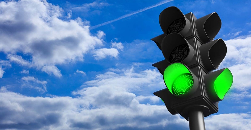 green traffic light concept; green go signal on blue sky background