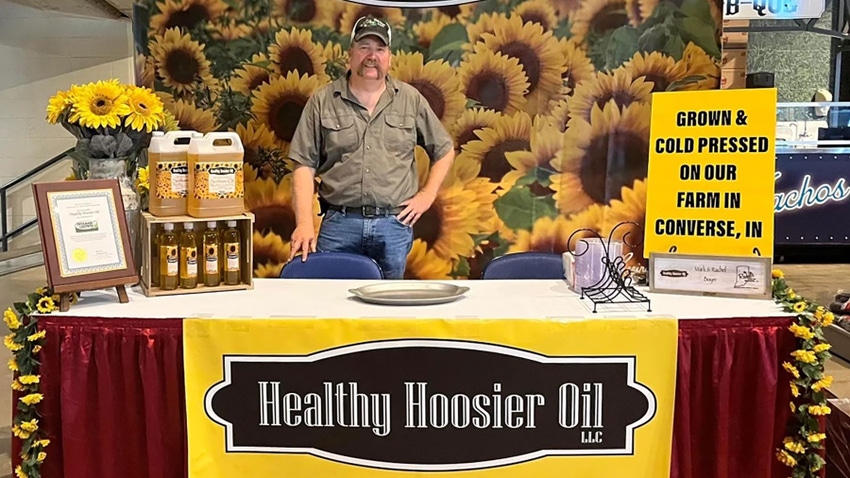 Mark Boyer stands behind a vendor table for Healthy Hoosier Oil