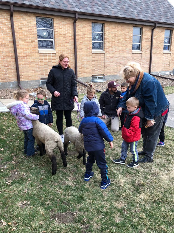 Claire and Danica  showcasing a set of twin lambs to a preschool class