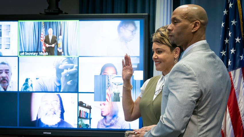 Jewel Bronaugh next to her husband being sworn in remotely by Tom Vilsack.