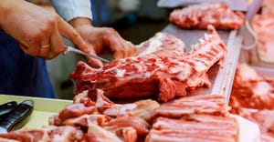 butcher cutting raw meat