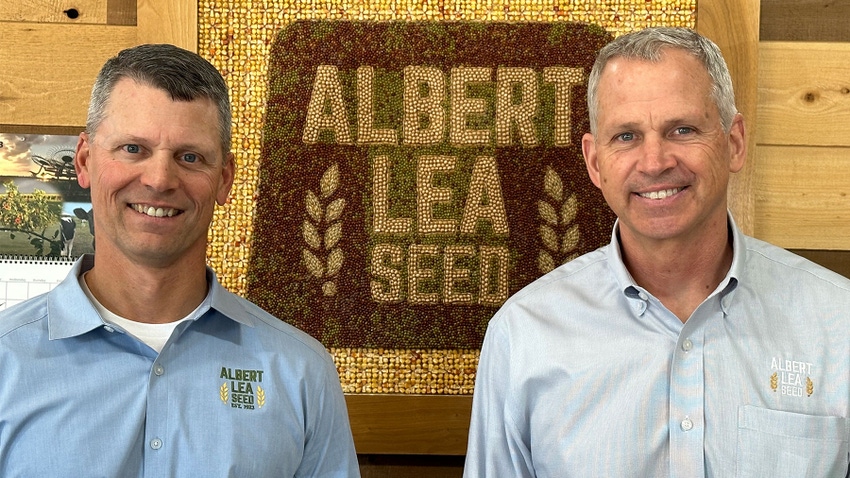 Two men flank an Albert Lea Seed mosaic 
