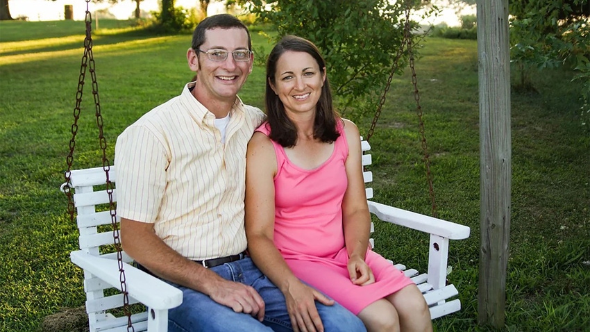  Nick and Beth Tharp sit on a wooden bench swing