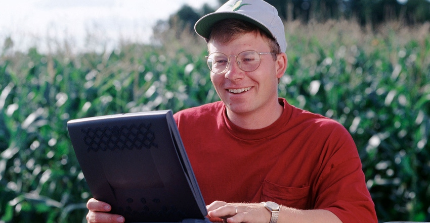 farmer using laptop in corn field