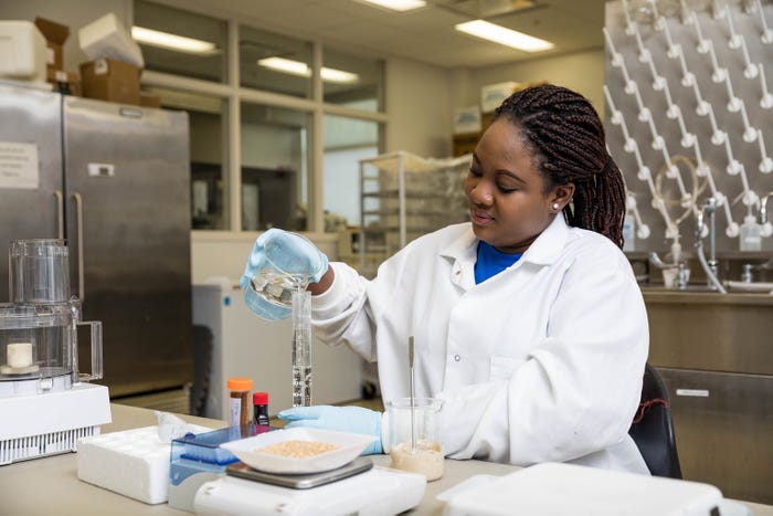 Graduate student Beatrice Manu of the SDSU Department of Dairy and Food Science adds an enzyme to a beaker
