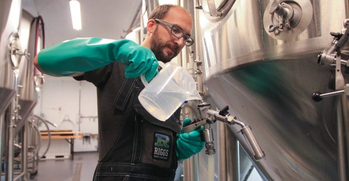 Kyle Schwenk sanitizes packaging equipment 