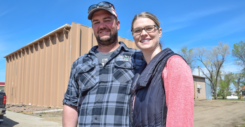 Austin and Allison Kruisselbrink posing in front of a processing plant Austin and Allison Kruisselbrink posing in front of a processing plant