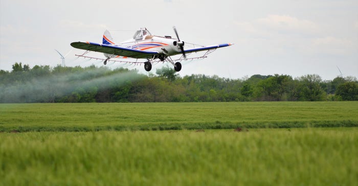 crop sprayer plane flying over field