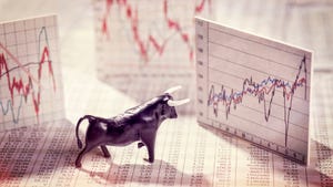 Bull figurine facing stock market graphs