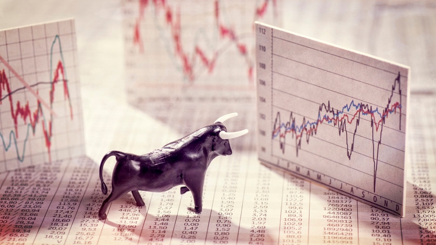 Bull figurine facing stock market graphs Bull figurine facing stock market graphs