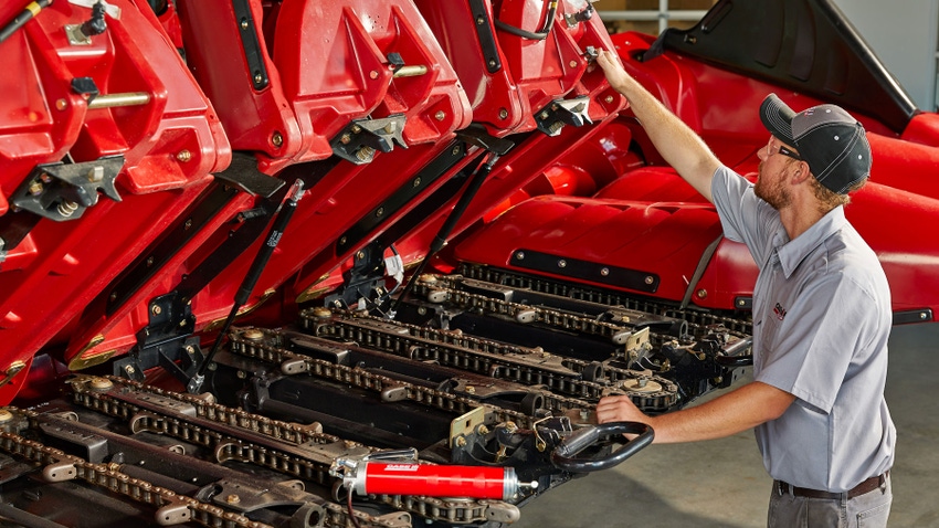 A mechanic checks over parts of the corn heads
