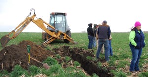 ditches being dug for subsurface drainage being put in field