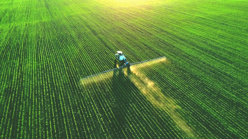 aerial shot of a tractor and sprayer in a field aerial shot of a tractor and sprayer in a field
