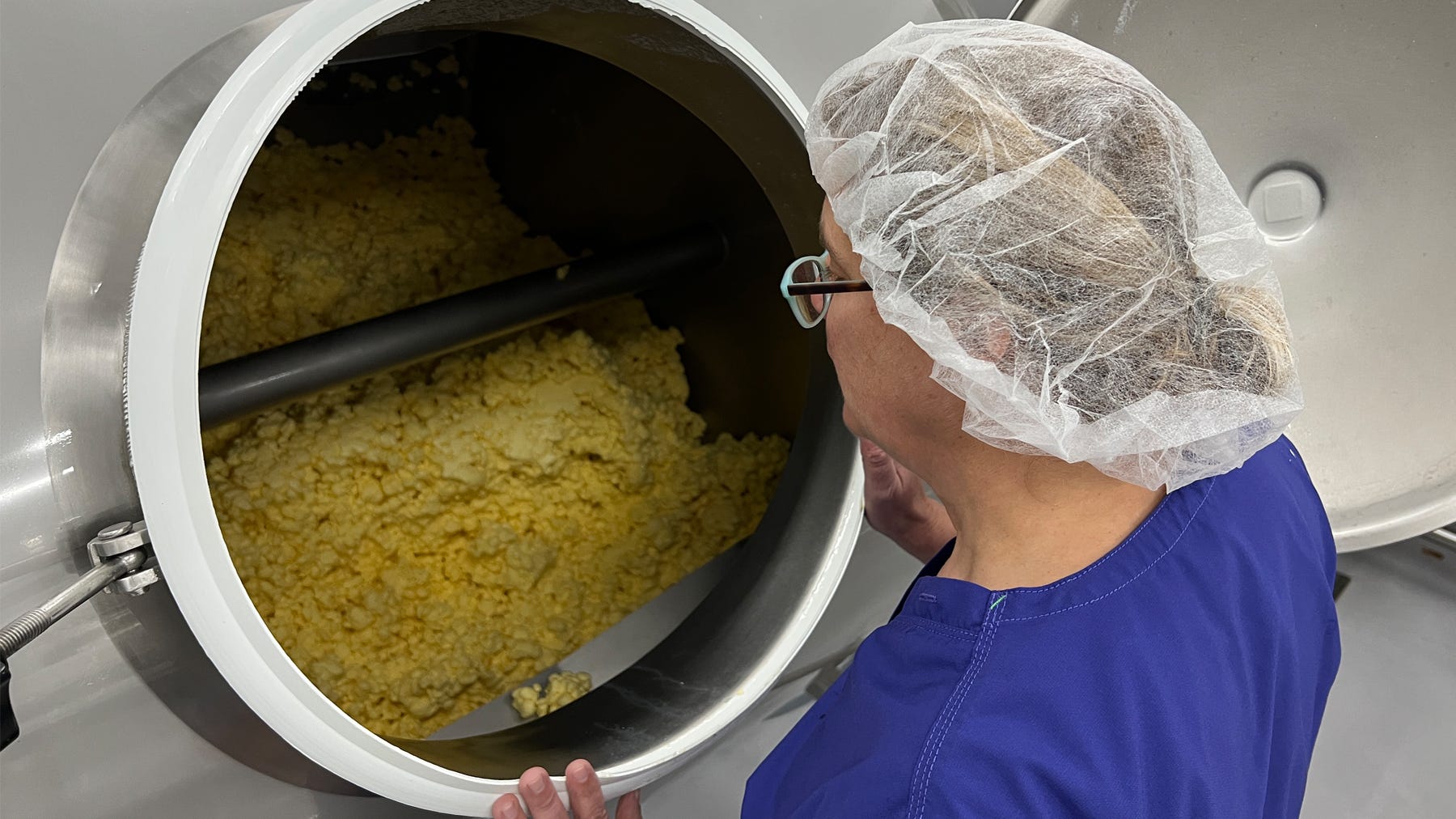 a woman checks the kernel size of butter in a batch churn