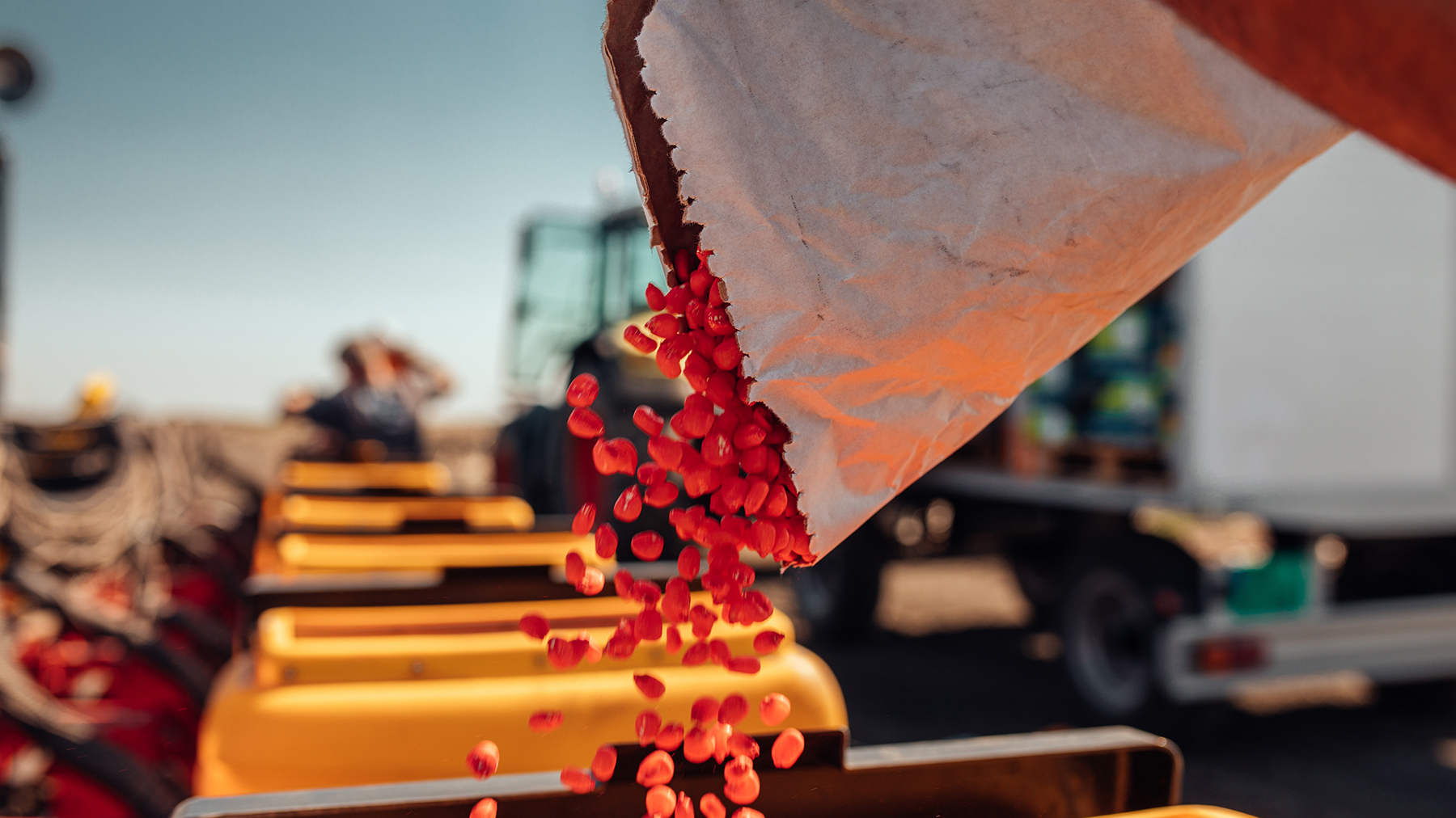 Farmer filling planter with treated seed in spring