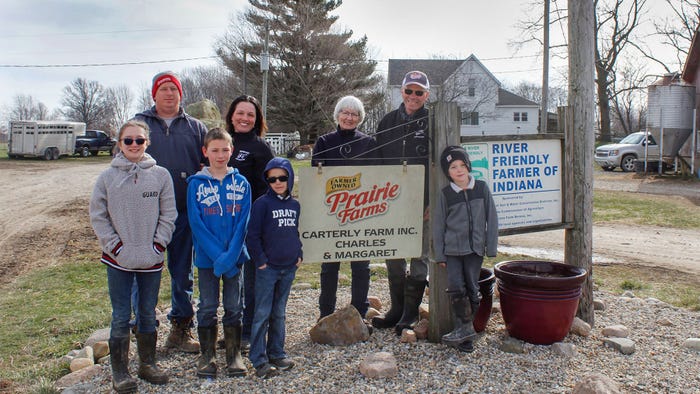  A family posing around a sign that reads Prairie Farms Carterly Farms Incorporated