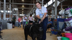 Brylee Williams smiles as she holds her swine close