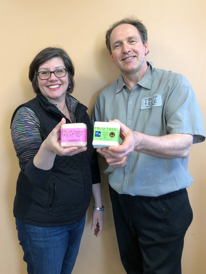 Laura Davenport and Fons Smits holding Tulip Tree Creamery cheese