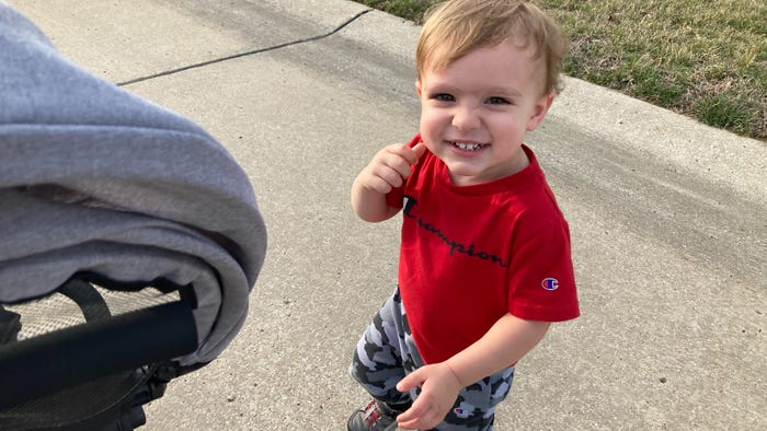 2-year-old boy in red shirt grinning