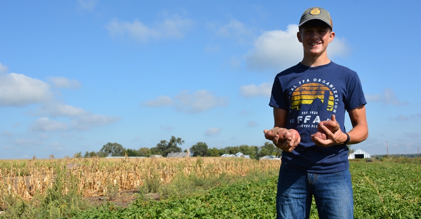 A boy, Carson Reiman, holding potatoes