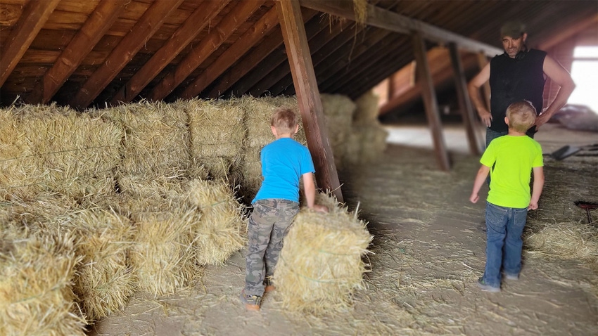 A man and his two young sons move hay bales A man and his two young sons move hay bales