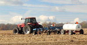 Tractor and toolbar pulling anhydrous tank in corn stubble