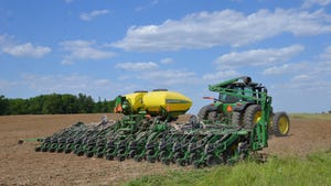 John Deere planter in field on cloudy, sunny day