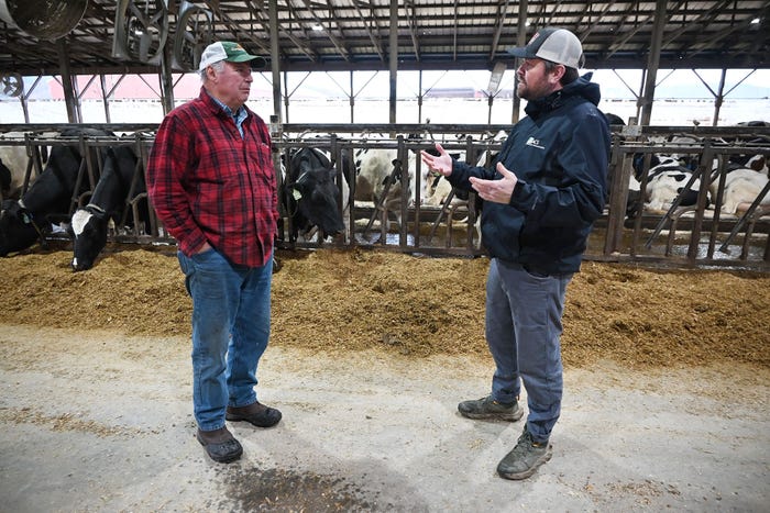 Chris Torres - Dave Conant and Tom Eaton engage in conversation near a dairy barn with cows