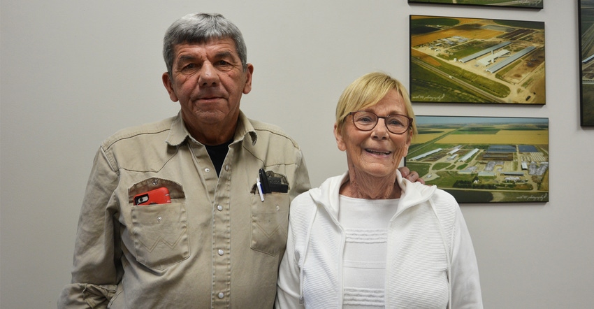 Tom and Judy McCarty standing infront of aerial images of their orignal farm at Rexford