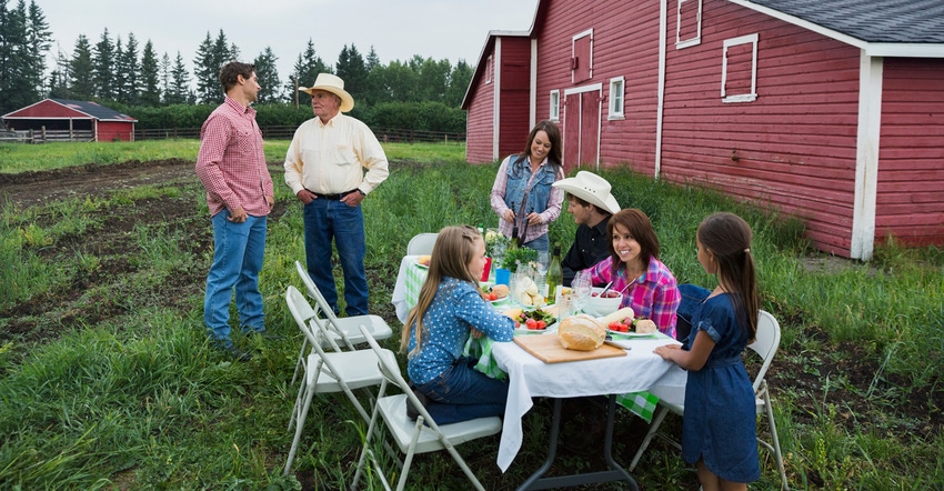 Multi-generation family enjoying dinner outside barn Multi-generation family enjoying dinner outside barn