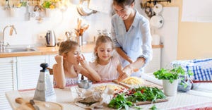 A family cooking a home made pizza with fresh ingredients