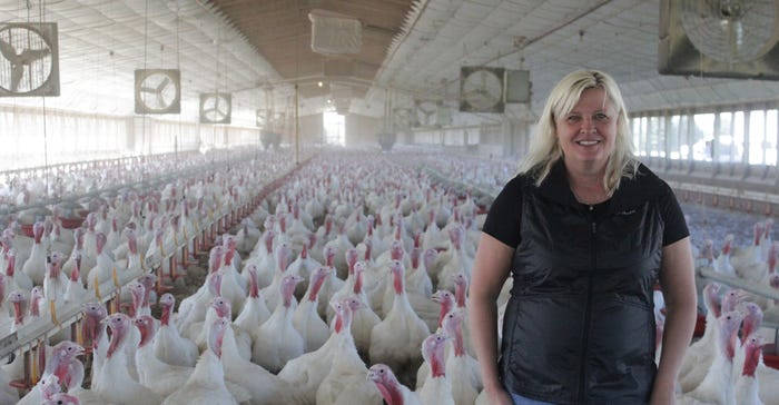 Sharlene Wittenburg inside barn with turkeys